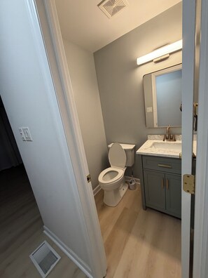 A bathroom with a toilet, sink, and cabinet. - Soothing room in a quiet house near Penn State (State College)