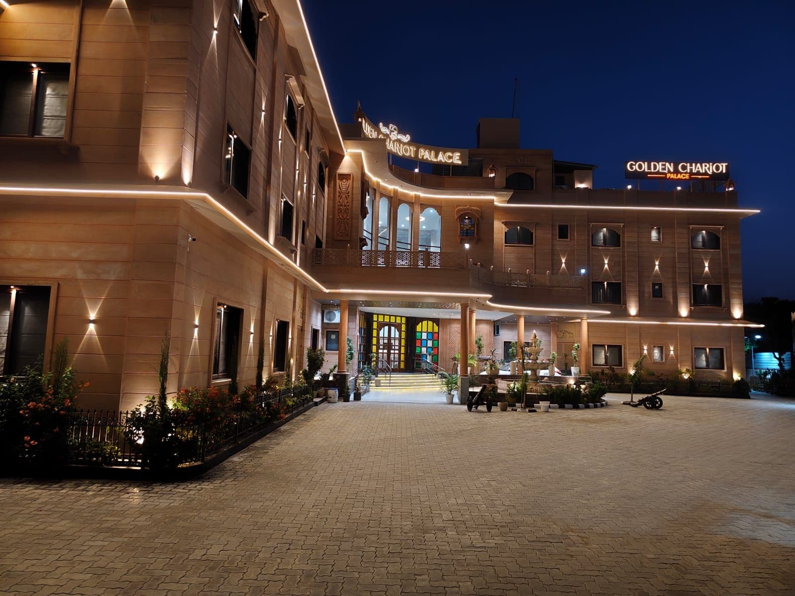 A hotel with a grand entrance, multiple floors, and a well-lit facade.