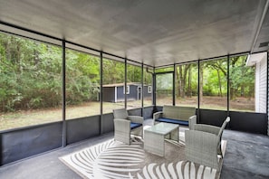 A covered outdoor seating area with wicker furniture and a patterned rug. - 5BR All King Beds Nature Mansion Retreat (Covington)