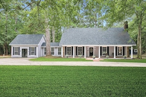 A two-story house with a covered porch and a well-maintained lawn. - 5BR All King Beds Nature Mansion Retreat (Covington)