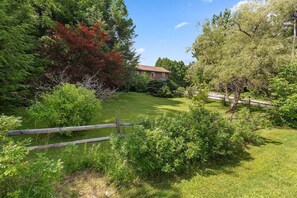 A residential property with a well-maintained lawn, a wooden fence, and a variety of trees and shrubs. - Killington Ski Haus | Sleeps 16, 5 Min K1, Hot Tub (killington)