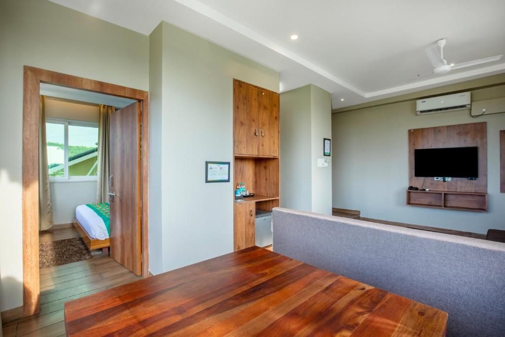 Une pièce comprenant une table à manger en bois, un téléviseur encastré et une armoire.