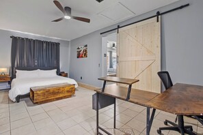 Une chambre à coucher avec un lit, un banc en bois, un bureau et une chaise.