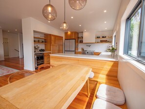 Eine moderne Küche mit Holzausstattung, einer Kochinsel und Pendelleuchten.