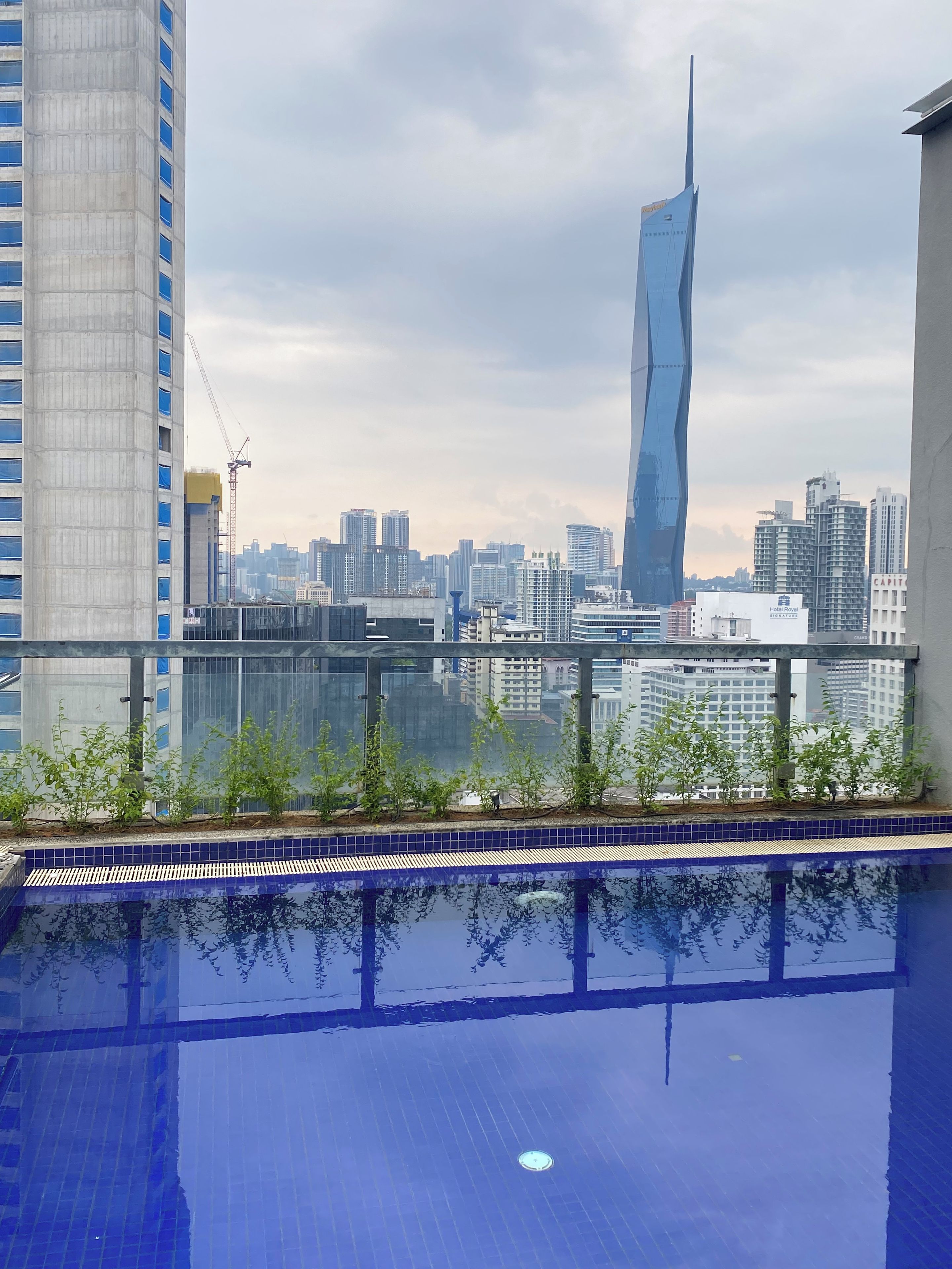A rooftop pool with a cityscape view, including a distinctive skyscraper.