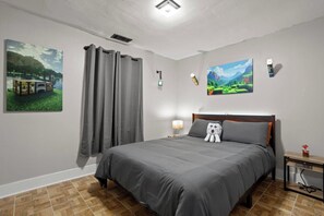 A bedroom with a bed, curtains, wall art, and a nightstand. - MineCraft Themed House - Hot Tub - King Bed (Gulfport)