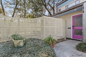 A fenced backyard with potted plants and a door. - X Men Themed King Bed with Bidet (Gulfport)