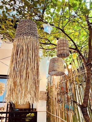 Ein dekoratives Objekt aus Naturmaterialien, möglicherweise ein gewebter Korb oder ein Kunstwerk, das an einem Baum hängt.