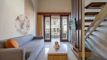 Una sala de estar moderna con un sofá, una mesa de centro y un televisor.