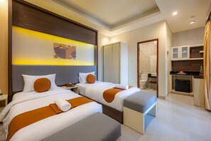 A hotel room with two beds, a small kitchenette, a bathroom, and a large mirror. - Cove Rumah Padi (Kabupaten Badung)