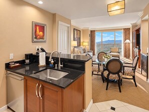 A hotel room with a kitchen, dining area, and a balcony with a city view. - MGM Signature 27F - F1 Track & Topgolf Views (Las Vegas)