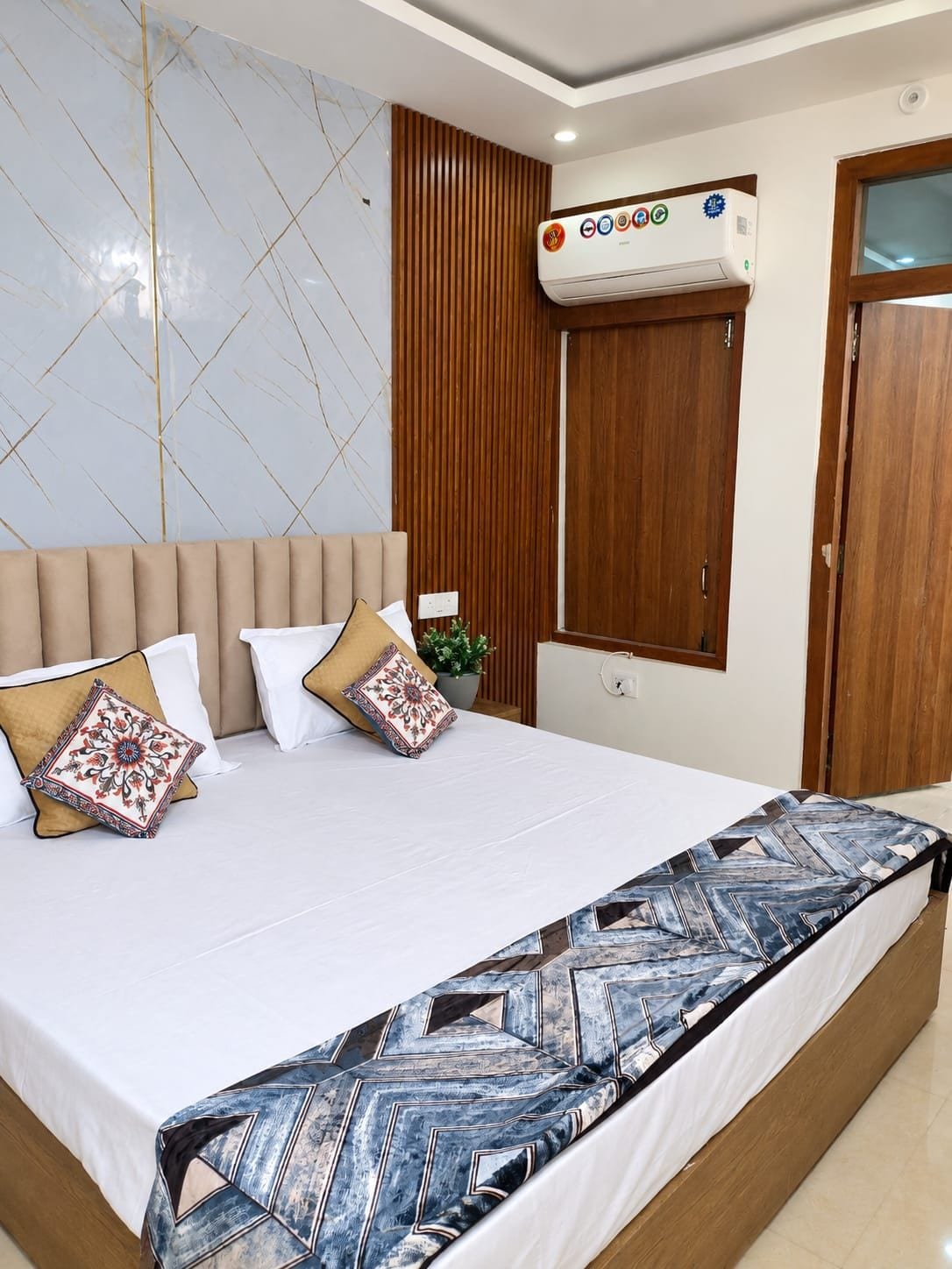 Un dormitorio con cama, aire acondicionado de pared y armario de madera.