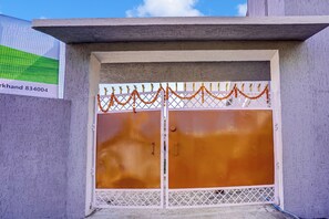A gated entrance with a metal door and a decorative garland.