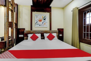 A hotel room with a bed, a painting on the wall, and a window with curtains. - Super Hotel O Oxygen (Samudrapur)
