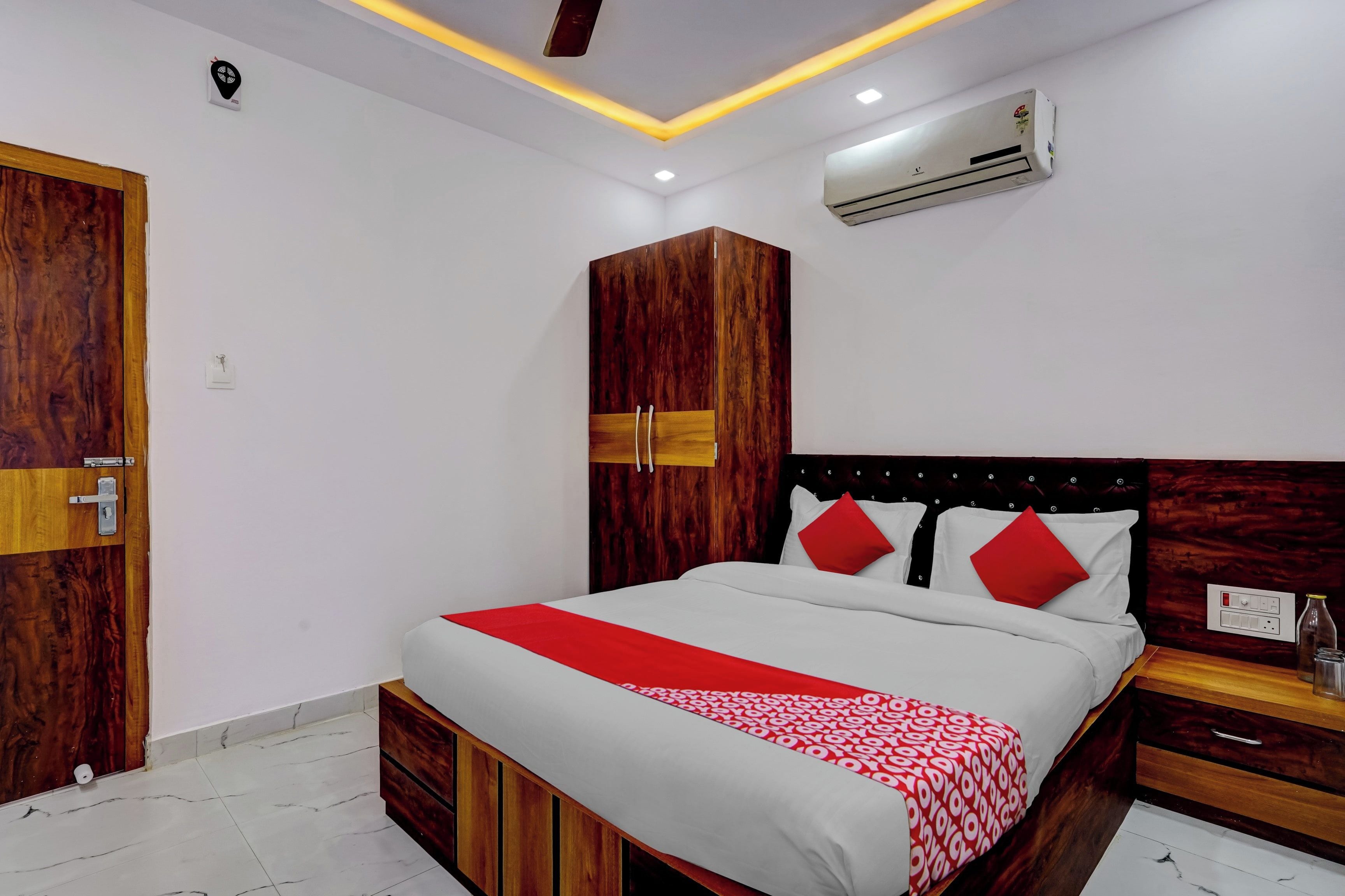 Un dormitorio con cama, armario de madera y equipo de aire acondicionado.