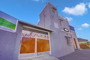 A building with a grey facade, a large garage door, and a sign indicating 'DPO'.