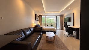 Een moderne slaapkamer met een leren bank, een bed, een bureau en een groot raam.