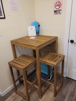 A small wooden table with a white bag on top and two chairs. A 'No Smoking' sign is visible on the wall. - Quiet Studio · Free Parking (Hollywood)