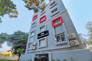 Un edificio de varios pisos con un cartel que dice 'OYO TOWNHOUSE'.