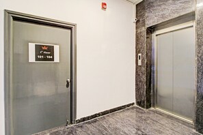 A hotel corridor with a door marked '1st Floor 101-104' and a marble wall. - Hotel O SS Skyline (Hyderabad)