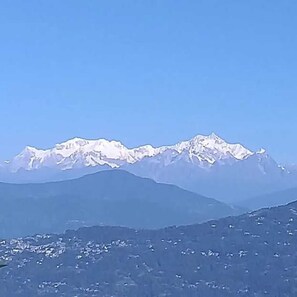A mountain range with snow-capped peaks under a clear sky. - PARIJAT HOMESTAY (Lulagaon Khasmahal,Kalimpong)