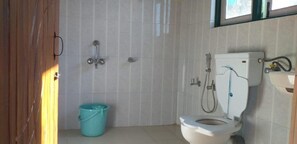 A bathroom with a toilet, a shower, and a sink. - PARIJAT HOMESTAY (Lulagaon Khasmahal,Kalimpong)
