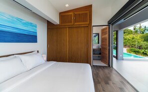 A modern bedroom with a large bed, wooden wardrobe, and a view of a swimming pool. - Villa Moana Relaxed Tropical Retreat Samui (Koh Samui, Surhat Thani)