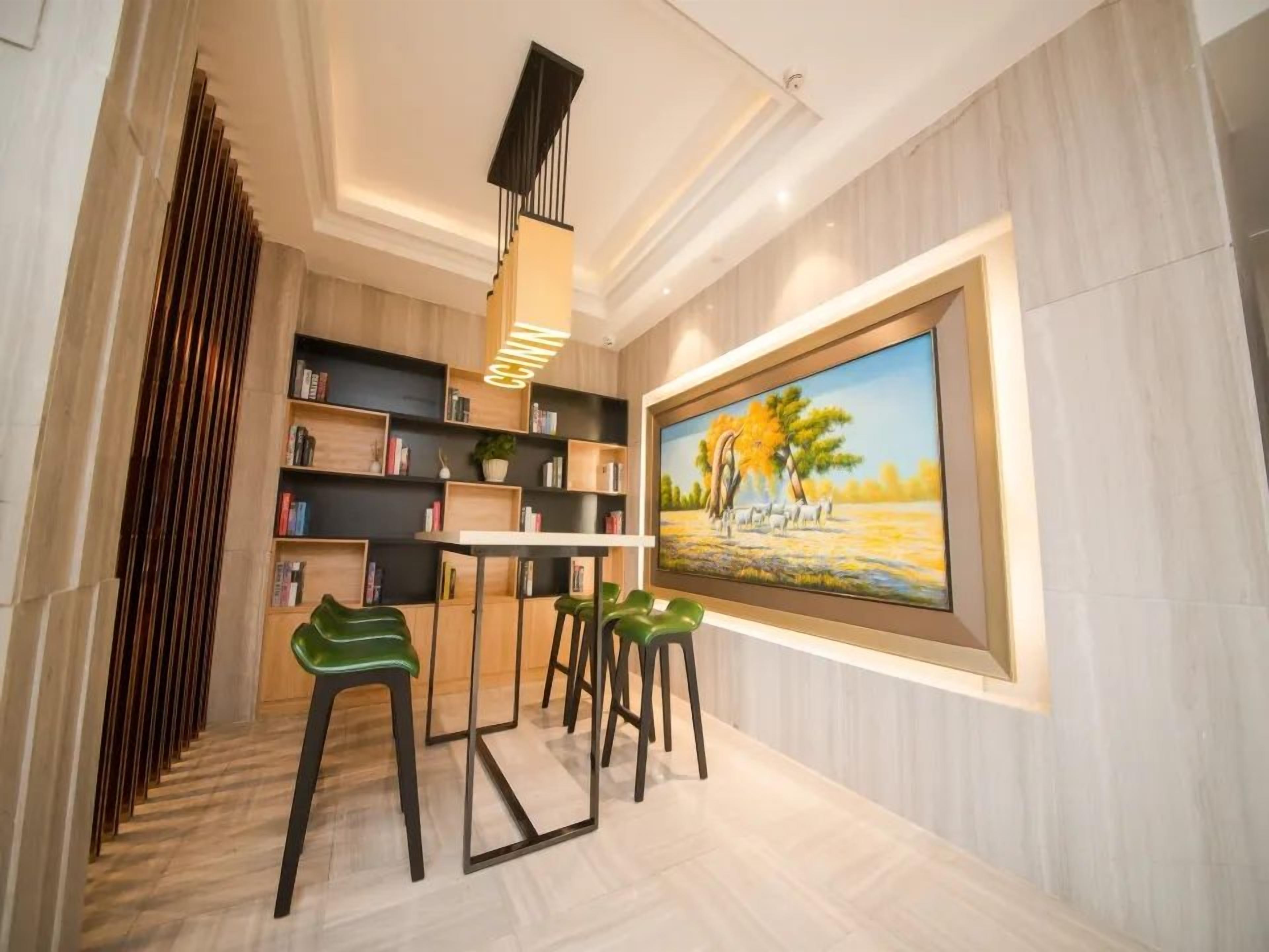A modern interior with a dining area, bookshelves, and a painting.