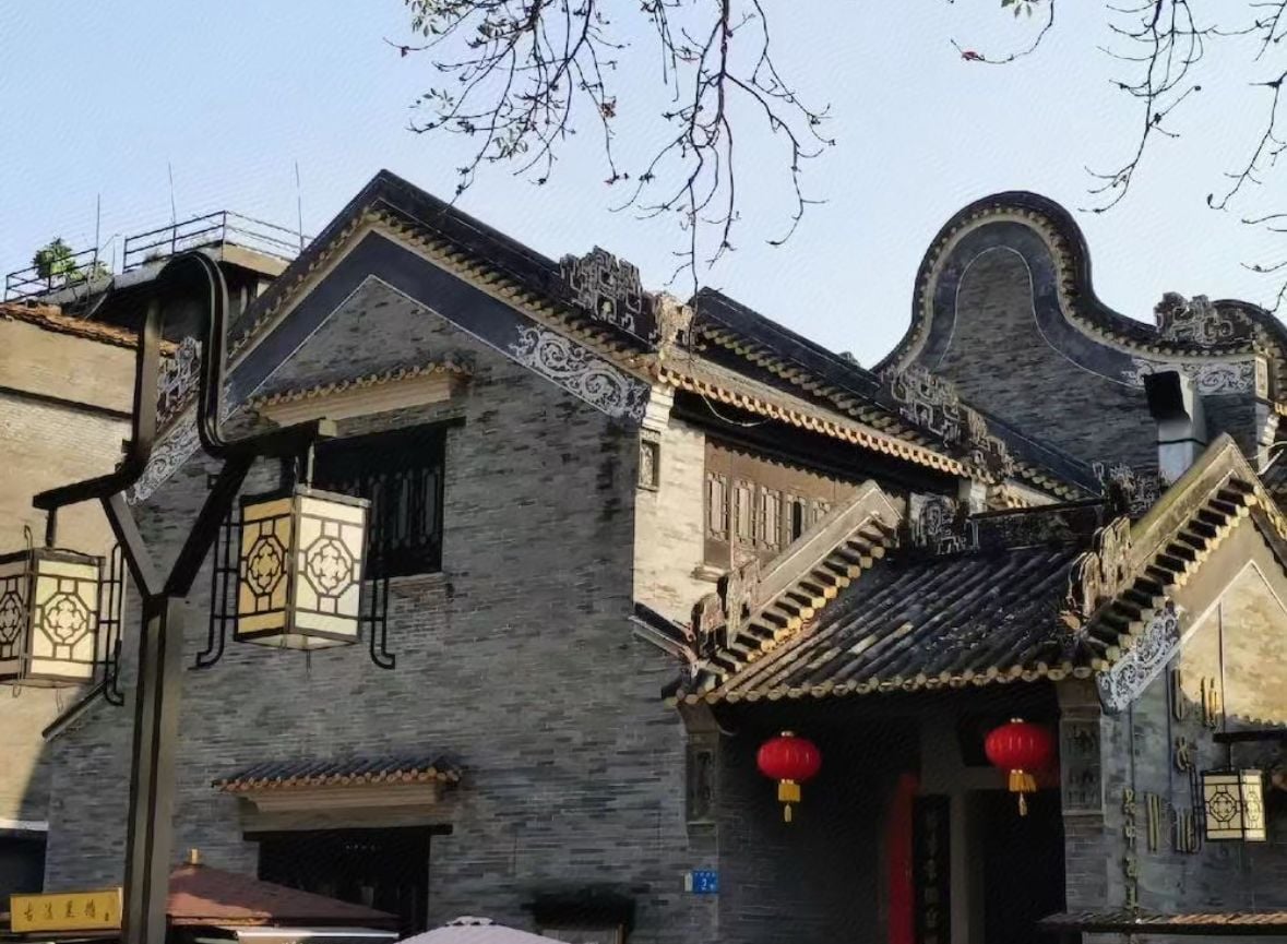 Un edificio tradicional con detalles arquitectónicos ornamentales, incluyendo un tejado de baldosas y faroles decorativos.