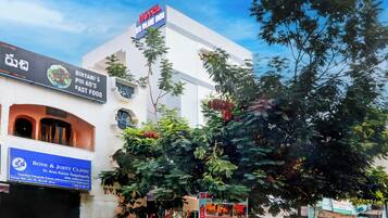 Un hotel con un cartel que dice 'Hotel S Blue Inn' y 'Clínica de Huesos y Articulaciones' en la planta baja.