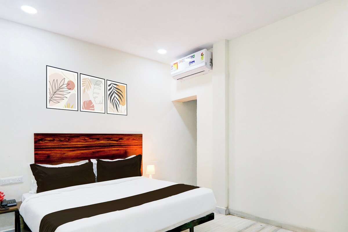 Una habitación de hotel con cama, mesita de noche, lámpara y decoración en la pared.