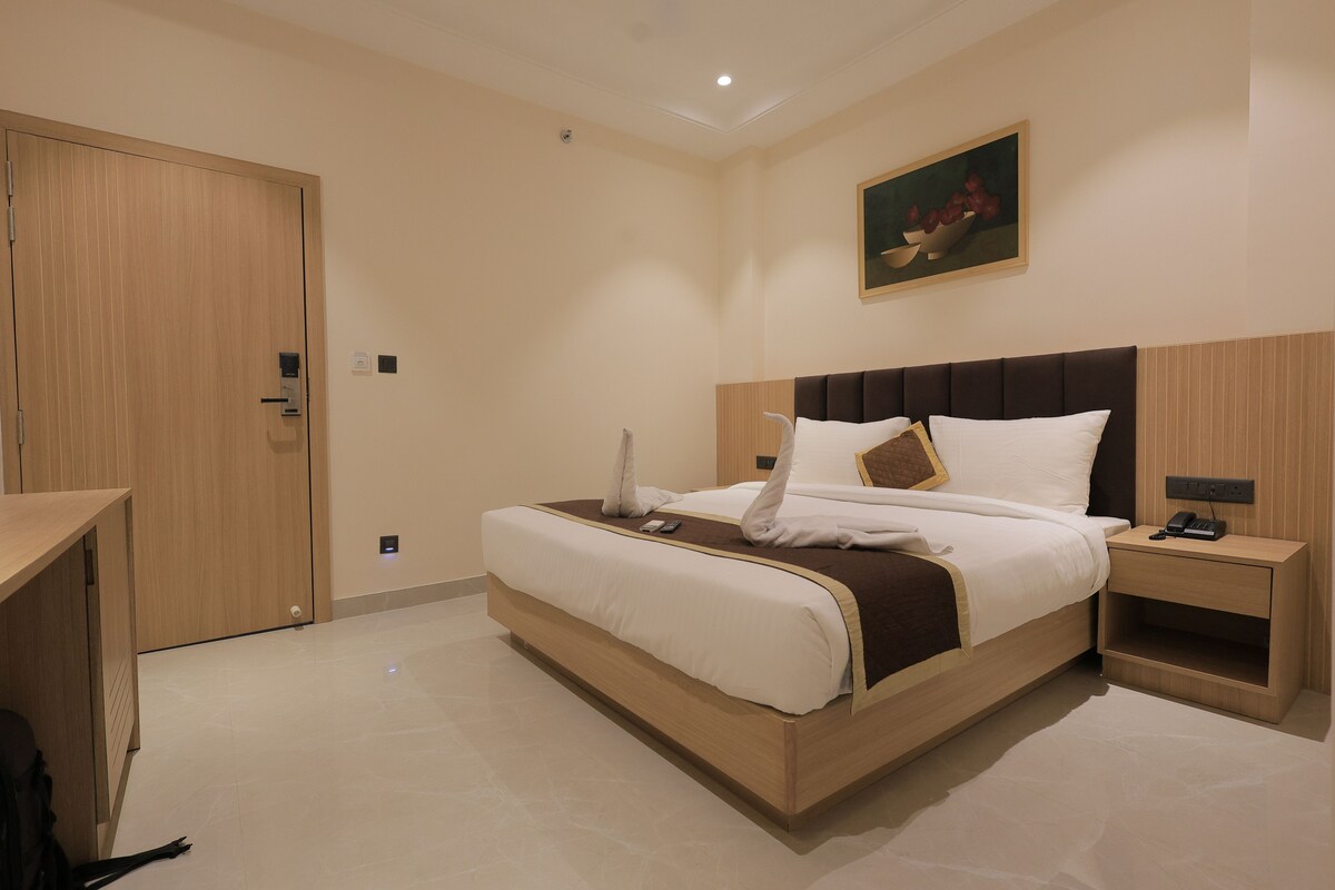 Una camera d'albergo con un letto, un comodino e un quadro appeso al muro.