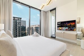A modern hotel room with a large bed, a TV, and a city view. - Premium 5BR Sobha Crest Grande (Dubai)