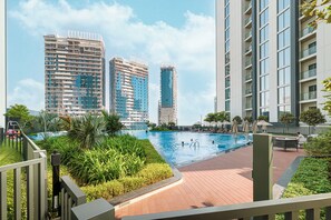 A swimming pool area with a view of high-rise buildings in the background. - Premium 5BR Sobha Crest Grande (Dubai)