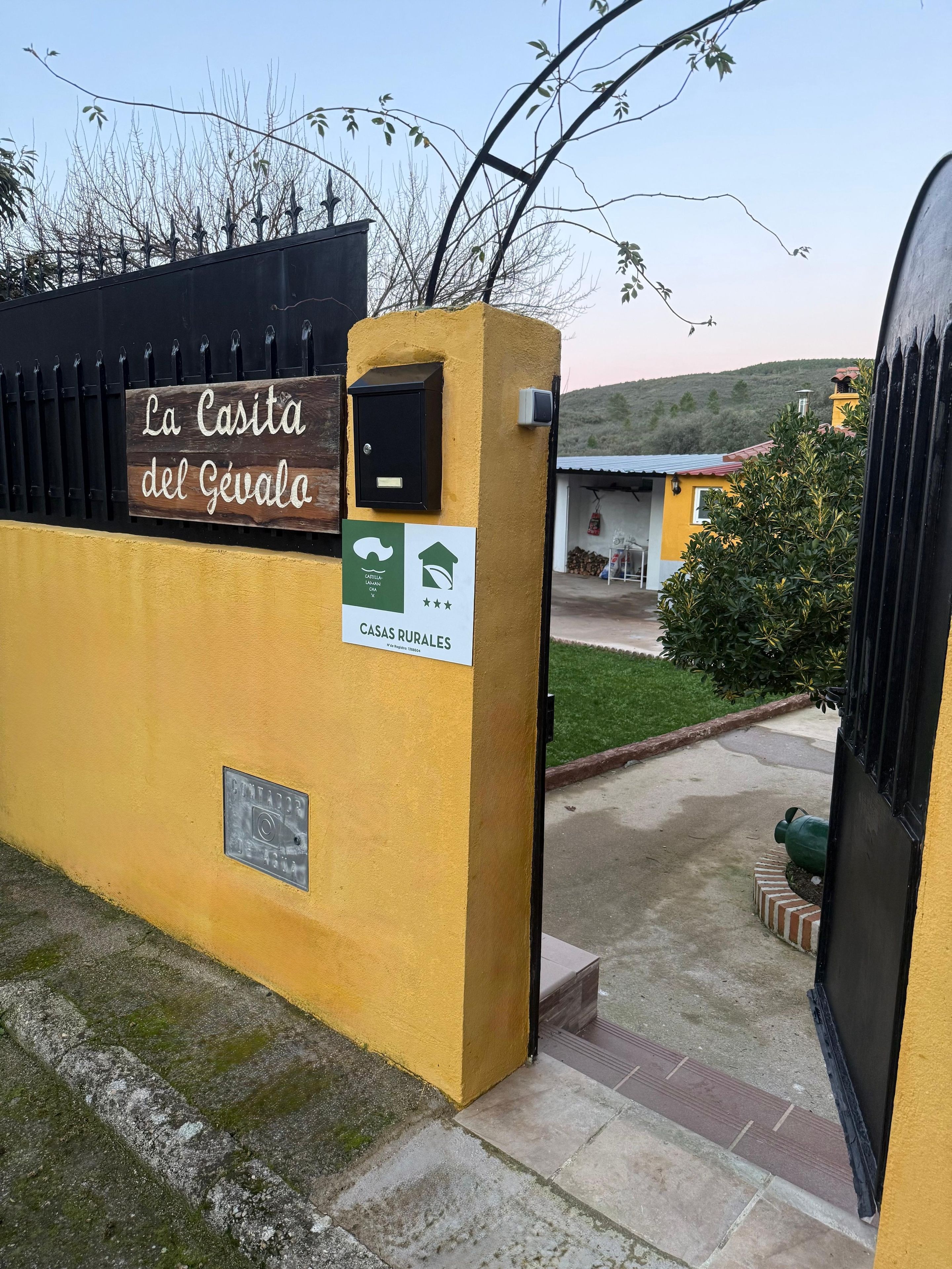 A gated entrance with a sign reading 'La Casita del Gévalo' and a green sign indicating 'CASAS RURALES.'
