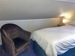 A bedroom with a single bed, a chair, and a nightstand with a lamp. - 1 bedroom accommodation in Inverness (Inverness)