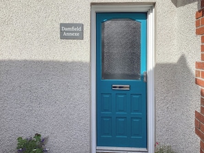 Eine blaue Tür mit einem Schild darüber, auf dem 'Damfield Annex' steht.