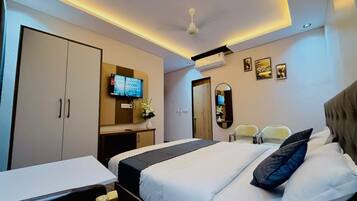 A hotel room with a bed, a desk, a TV, a mirror, and a wardrobe.