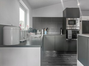 Eine moderne Küche mit integriertem Mikrowellenherd, Backofen und Geschirrspüler.