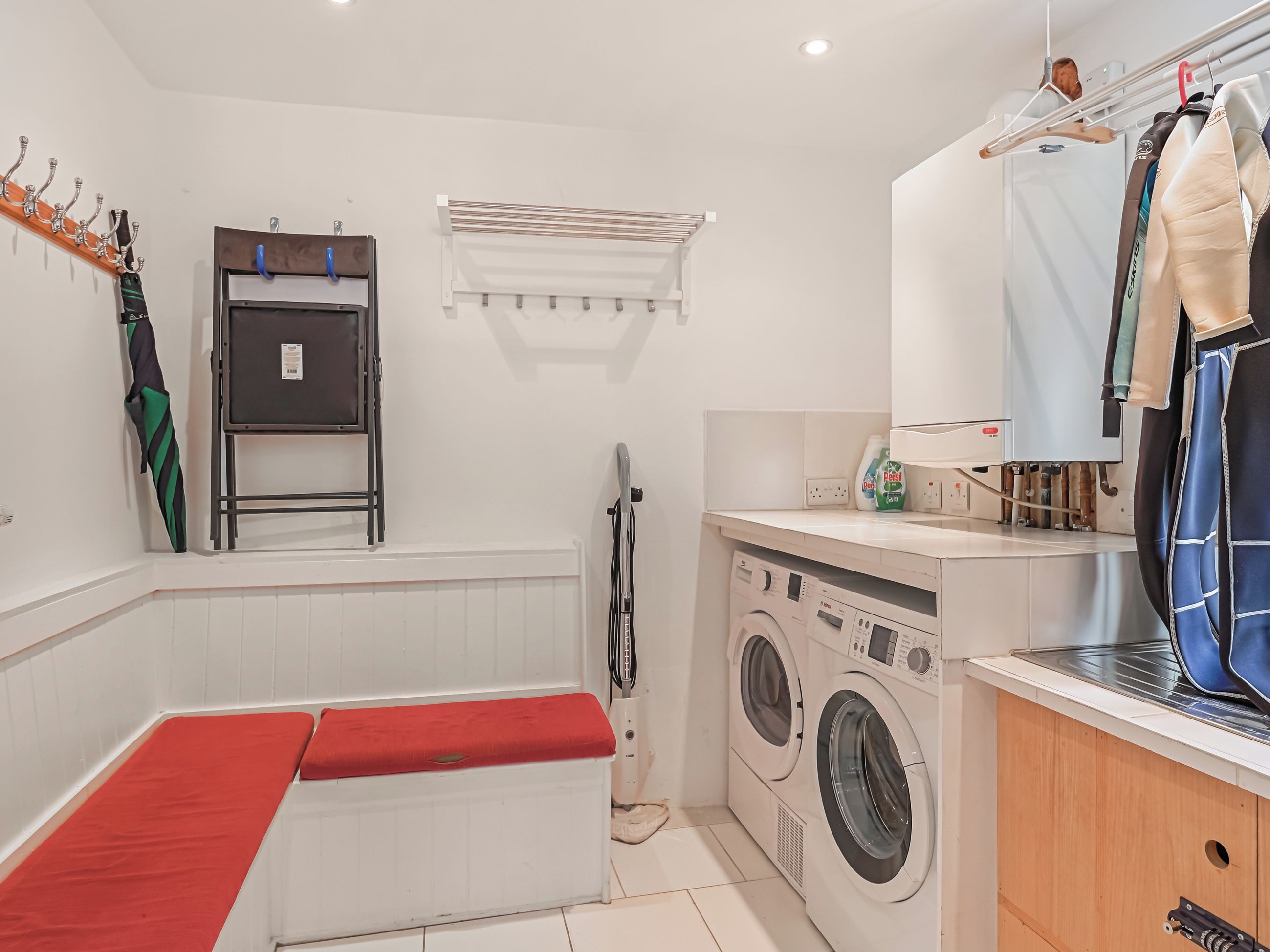 Un cuarto de lavado con lavadora, secadora y plancha.