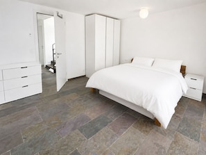 A bedroom with a bed, a wardrobe, a nightstand, and a dresser. - Chalet Aurea Appartement/Fewo 8-Bettwohnung by Interhome (Saas-Fee)