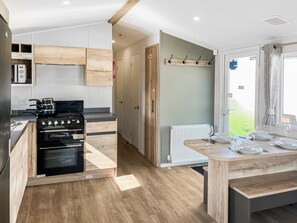 Een moderne keuken met een fornuis, oven en houten kasten.