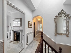 A hallway with a fireplace, a mirror, and a radiator. - 5 bedroom accommodation in Whitby (Whitby)