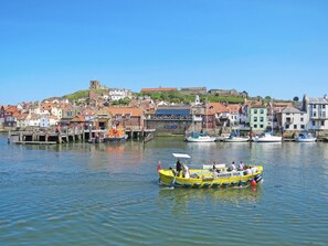 Un puerto con barcos, un muelle y edificios al fondo.