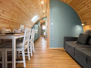 A cozy interior with a dining area, a sofa, and a curved wooden ceiling. - 1 bedroom accommodation in Blackpool (Blackpool)