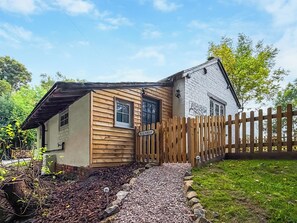Ett tvåvåningshus byggt av trä, med en skylt som visar texten ”Den gamla verkstaden”.