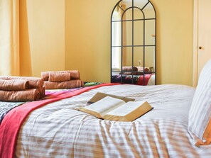 Ein Hotelzimmer mit einem Bett, einem großen Spiegel und einem Fenster.