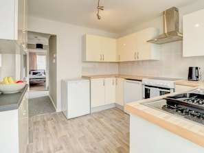 A modern kitchen with a built-in oven, a stove, and a refrigerator. - 2 bedroom accommodation in Niton (Niton)