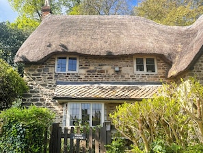 A stone cottage with a thatched roof, two windows, and a wooden gate labeled 'Wans Cottage.' - 3 bedroom accommodation in Sandy Lane (Sandy Lane)