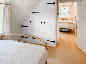A bedroom with a bed, a wardrobe, and a view of another room. - 3 bedroom accommodation in Sandy Lane (Sandy Lane)